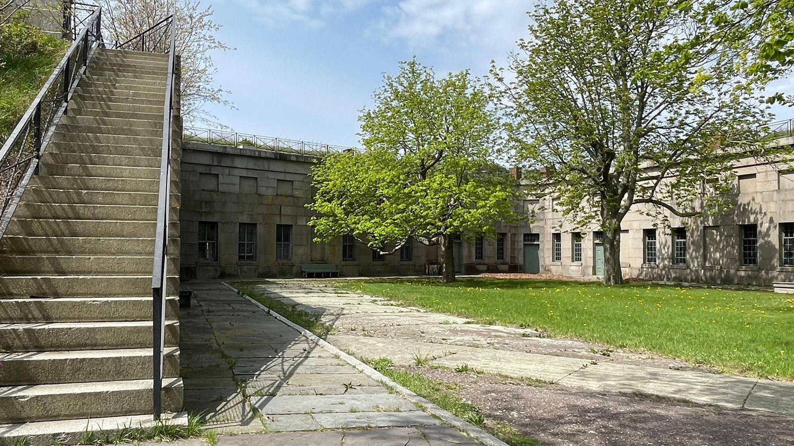 Courtyard in Fort surrounded by three stone walls. Stone walls have windows.