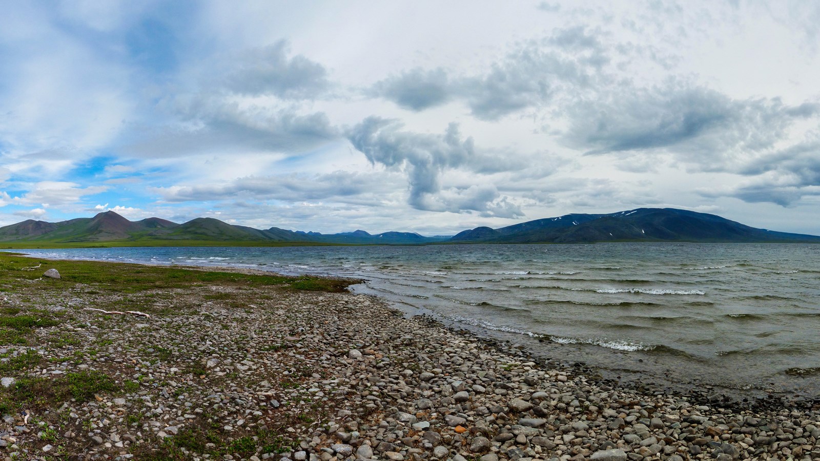 large, calm lake surrounded by rocks and mountains
