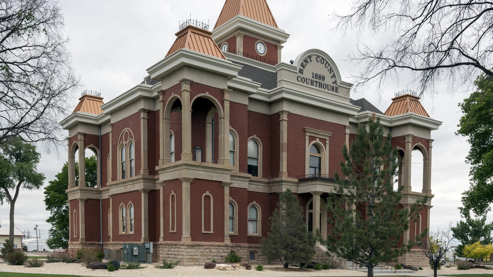 A two story red brick building built in the Victorian style with the addition of romanesque arches.