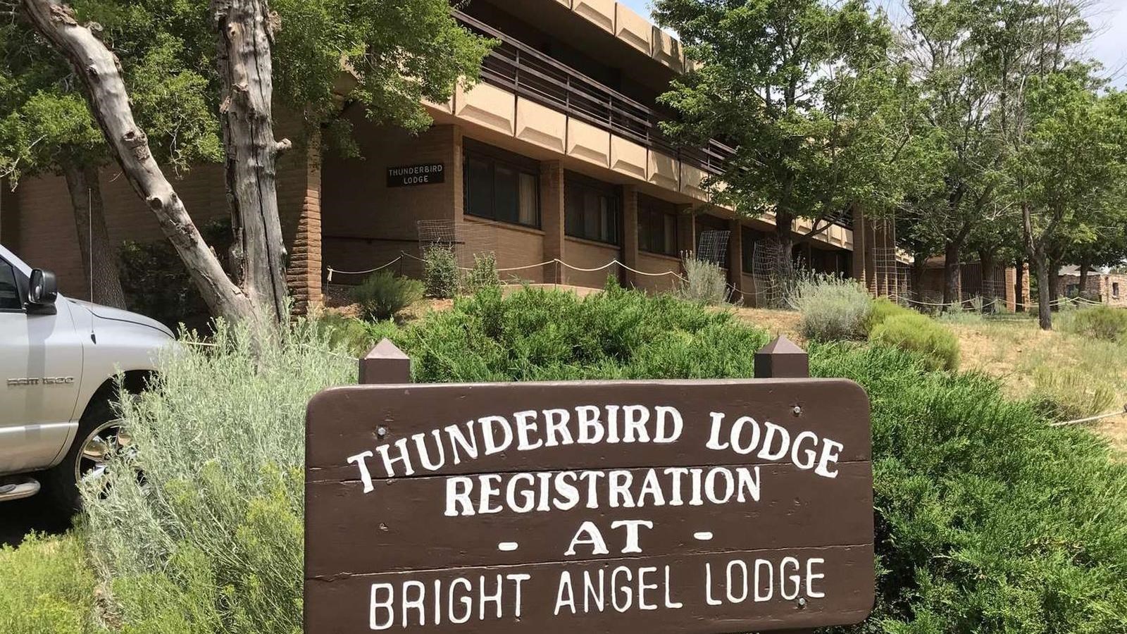 a contemporary two-story building of beige bricks. A wood registration sign. is in the foreground.