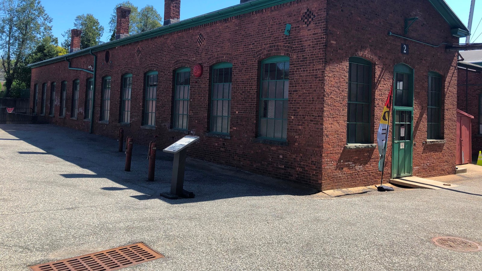 Long rectangular one story red brick building. sky in background