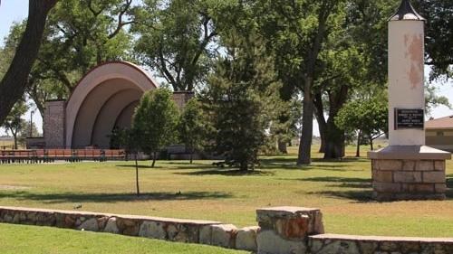 Grassy park with trees, pavilion, and obelisque monument.