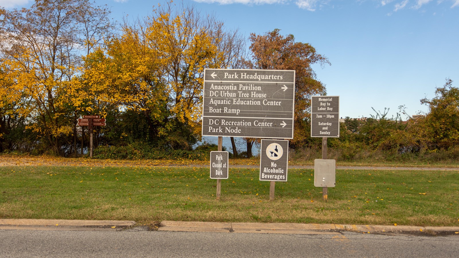 Four signs are displayed on three posts. The letters displayed are white on a gray/brown background.