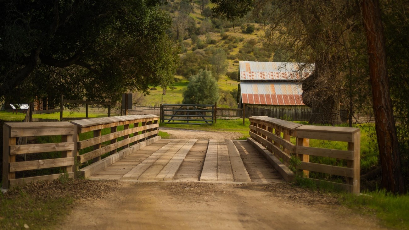 Wooden bridge entry to small ranch.