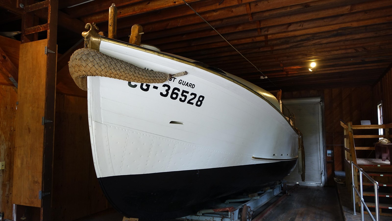 White surfboat on exhibit in the boathouse