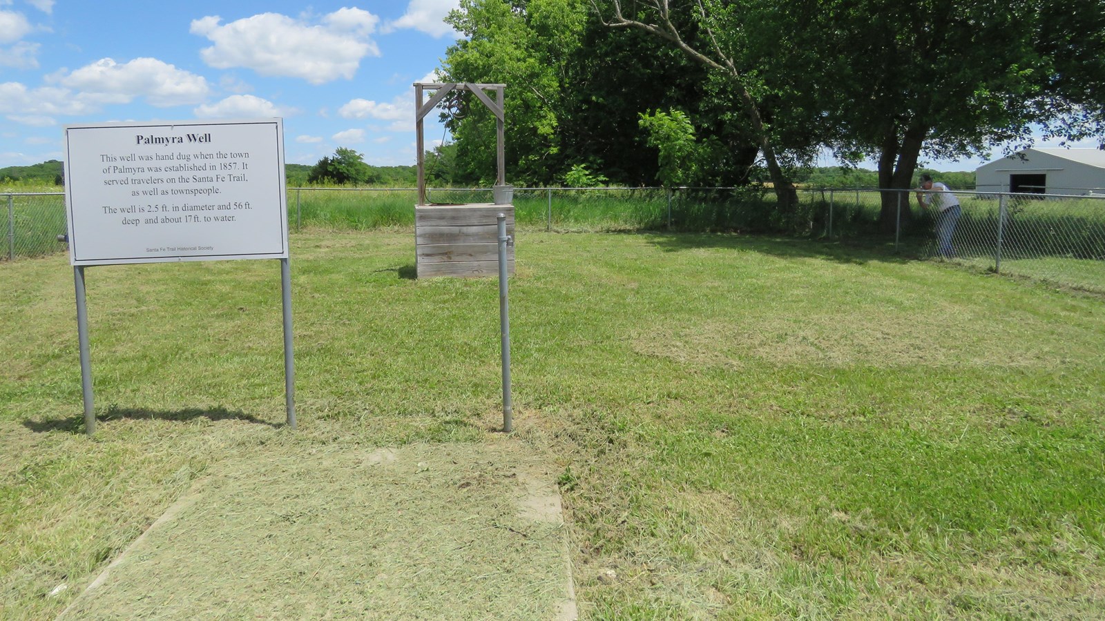 Two upright signs standing in a grassy field.