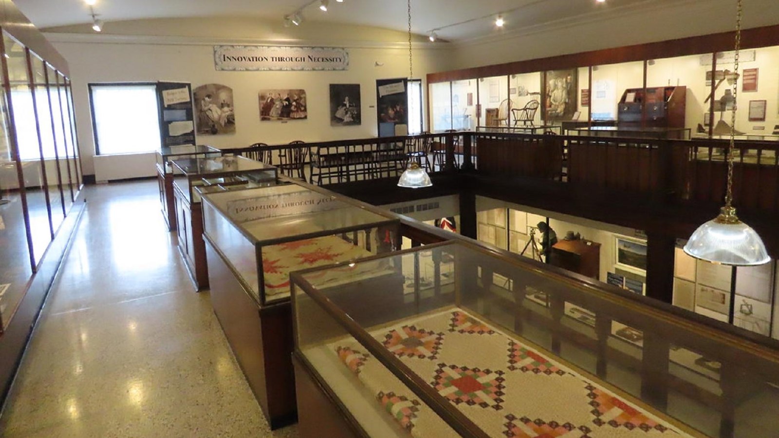 Exhibit cases on the second floor of the museum showcase quilts