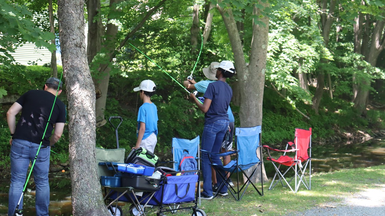 Group of people along Canal fishing poles