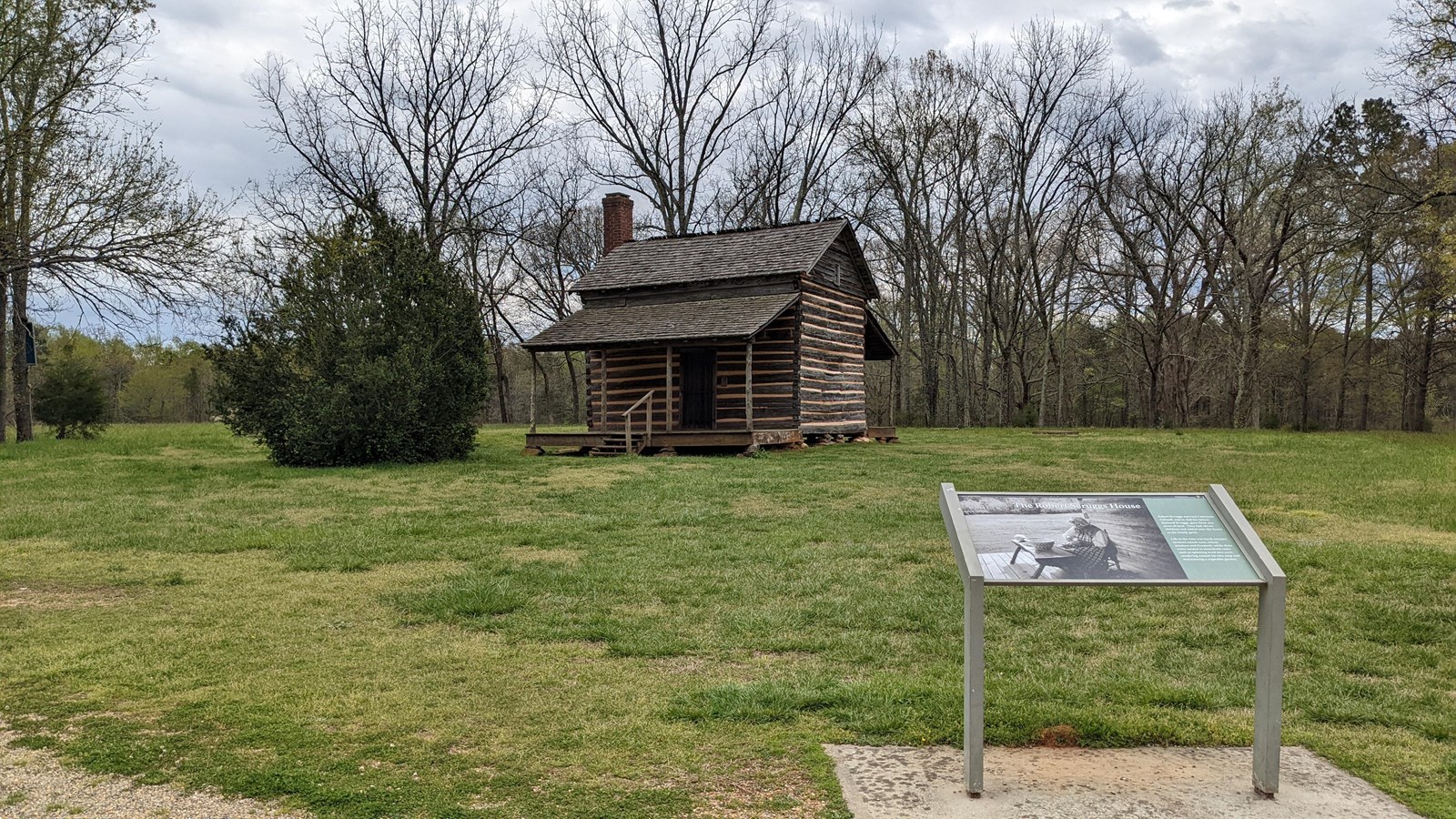 1820s log cabin with a way side on the front right.