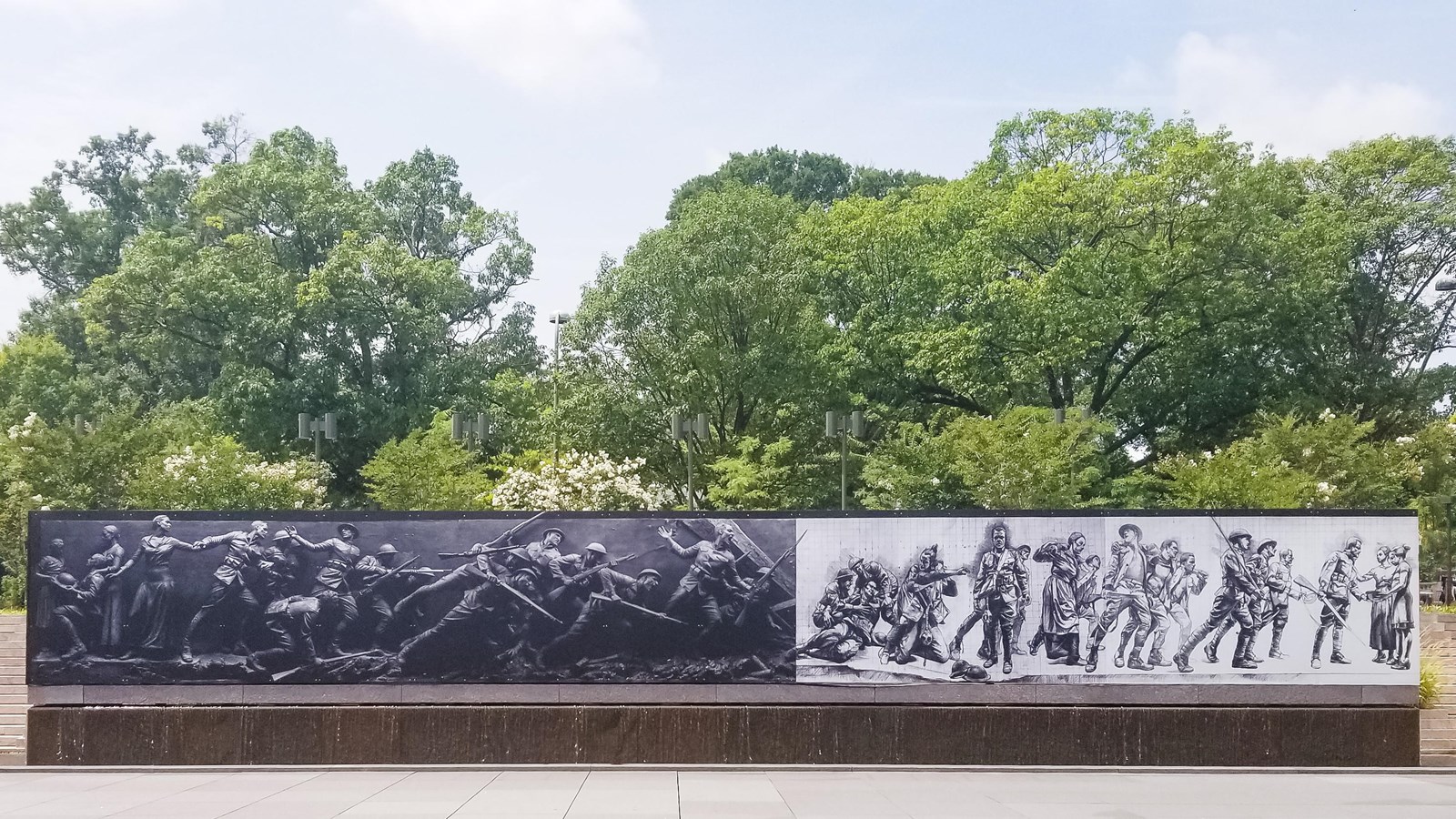 Brown metal mural featuring different figures to show the stages of war