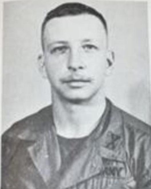 Young man wearing a US military uniform with trimmed hair. 