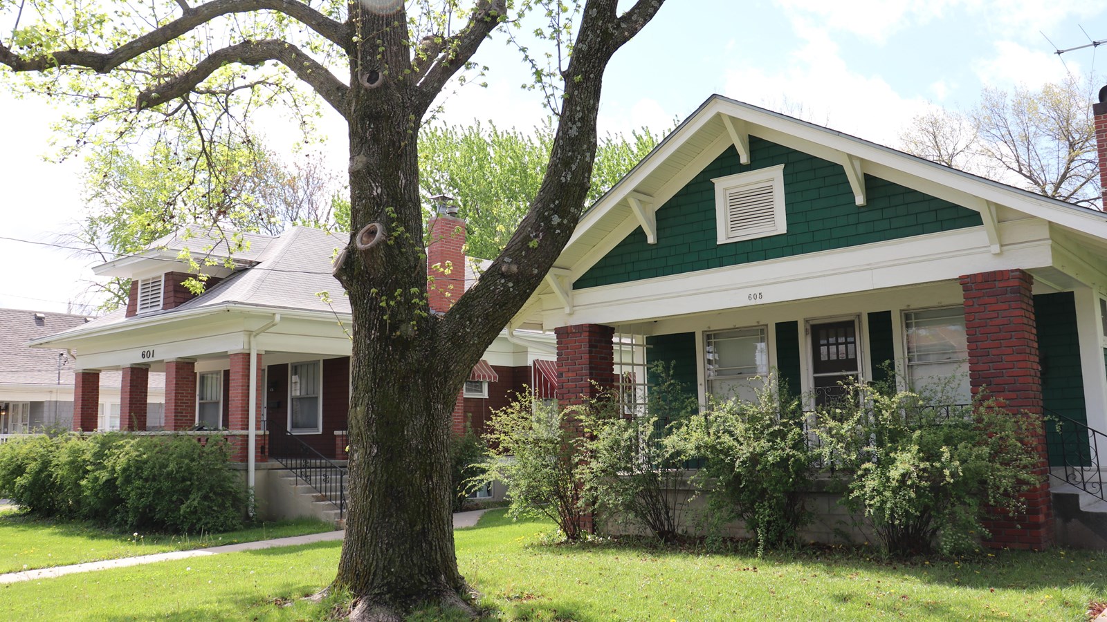 In the foreground, a green 1 story bungalow.  In the background, a red 1 story bungalow.