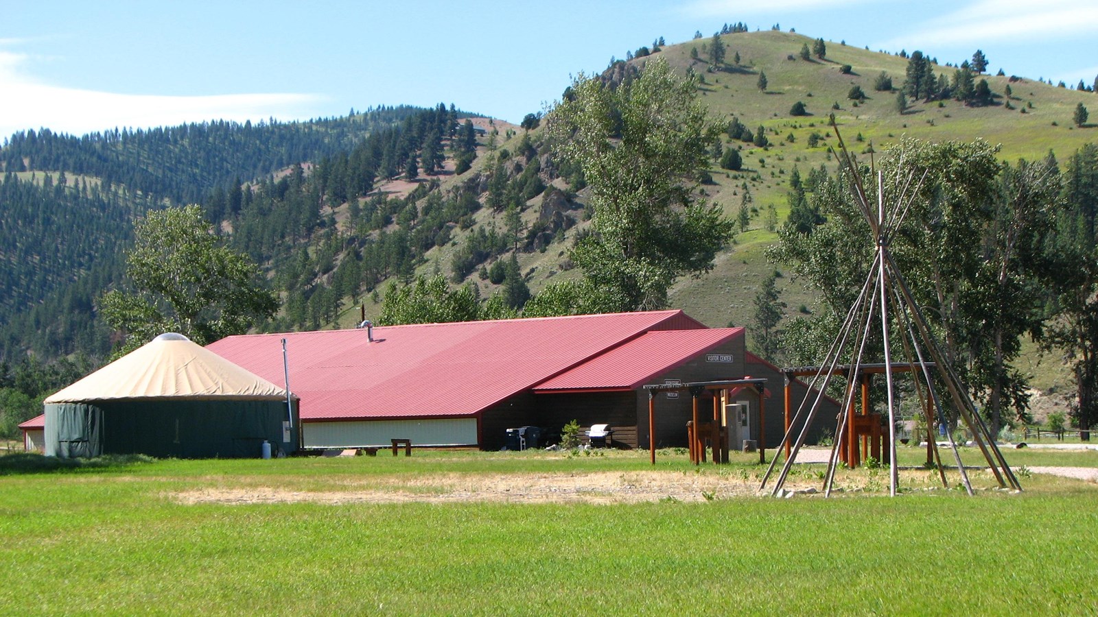 Grass lawn with large building with red roof in the background