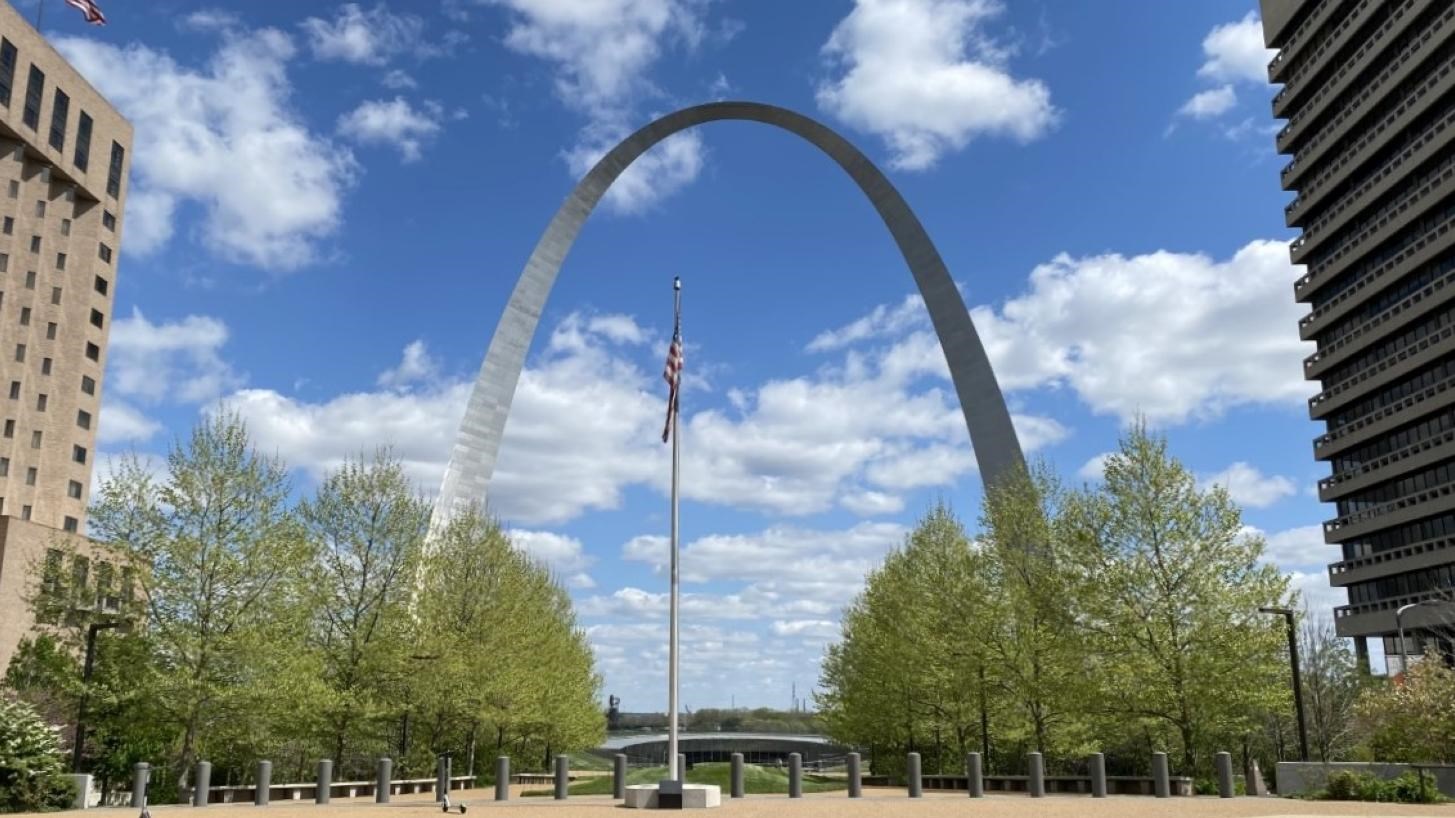 a flagpole in front of the Gateway Arch
