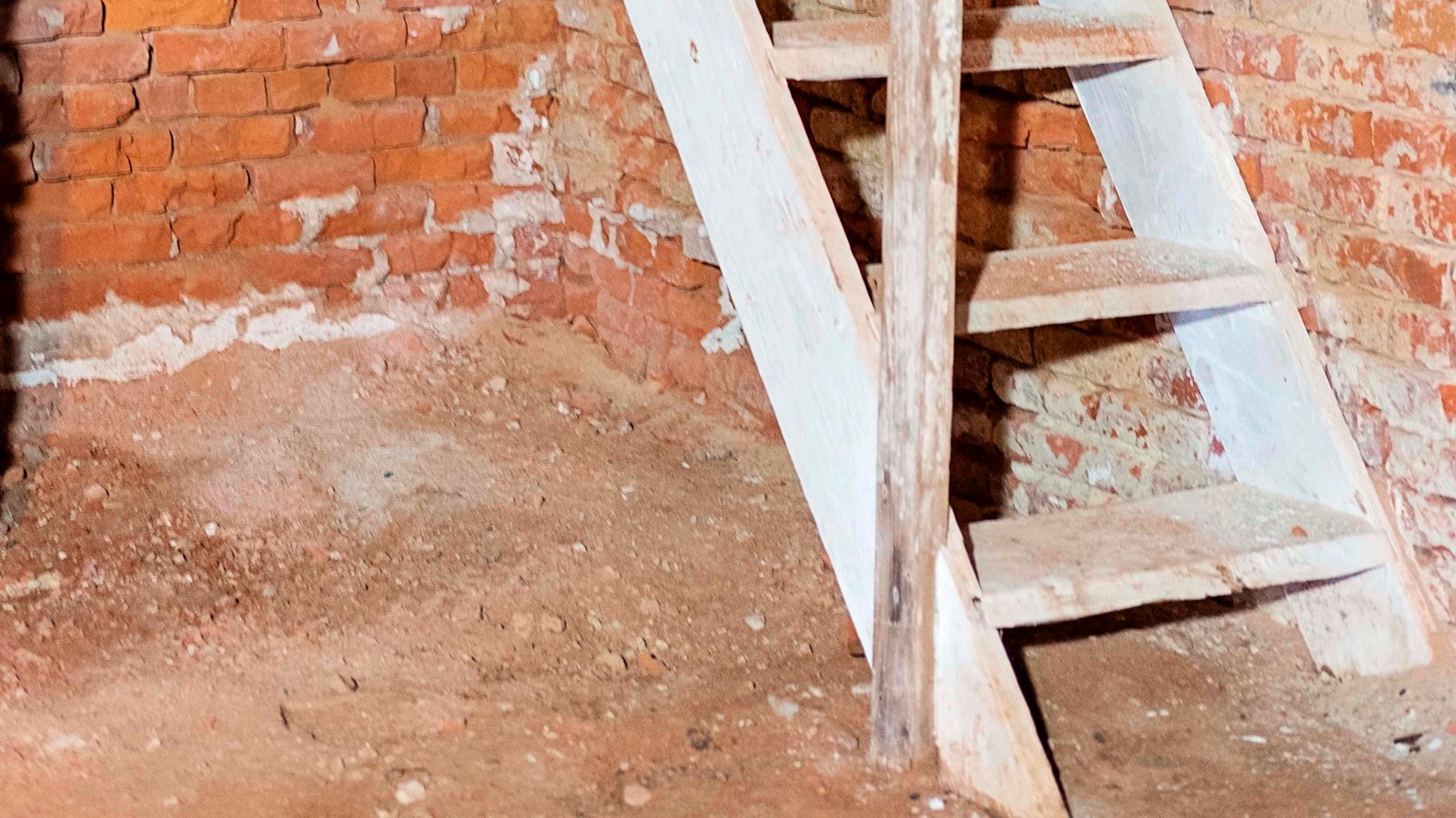 White wooden stairs lead from the enslaved nanny\'s room to the bedrooms above.