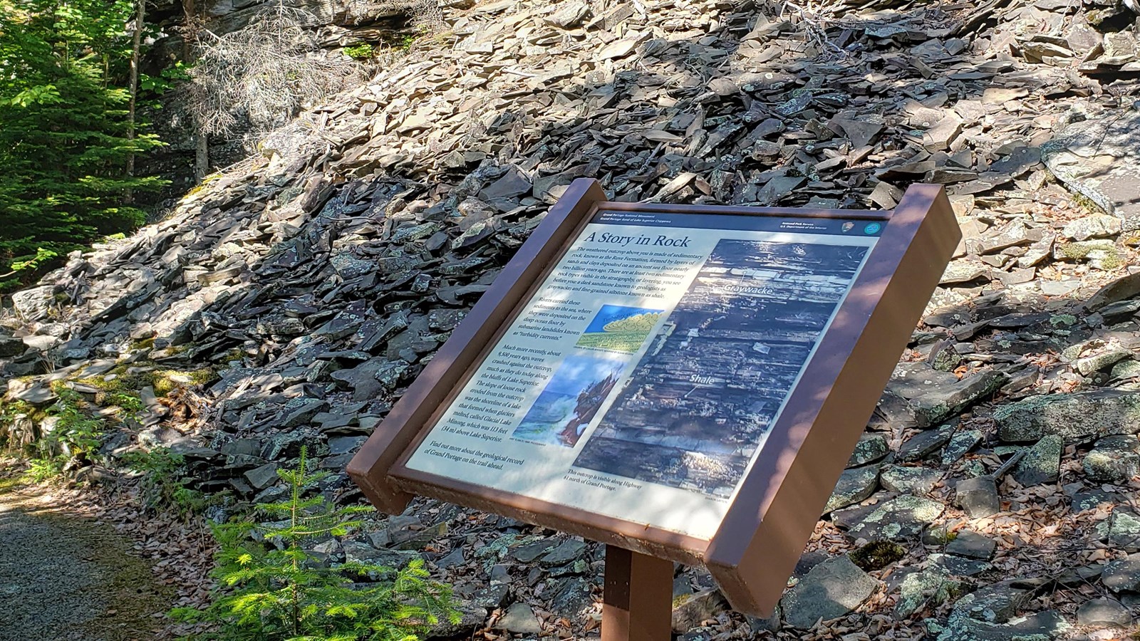 A wayside in front of a scree slope.