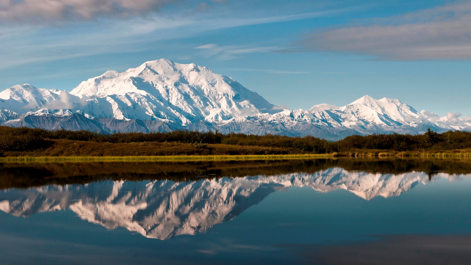snowy mountains reflected in a still pond