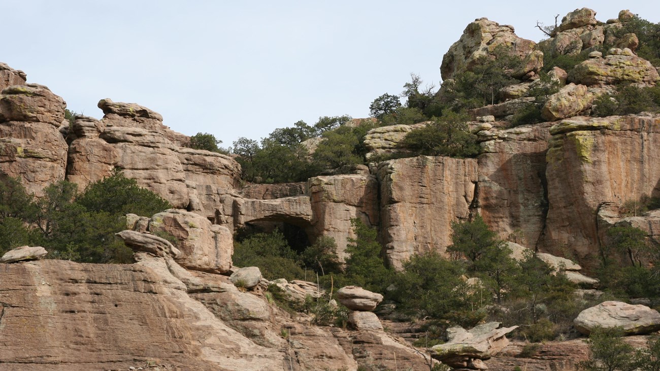 Rock formations with a natural bridge featured.