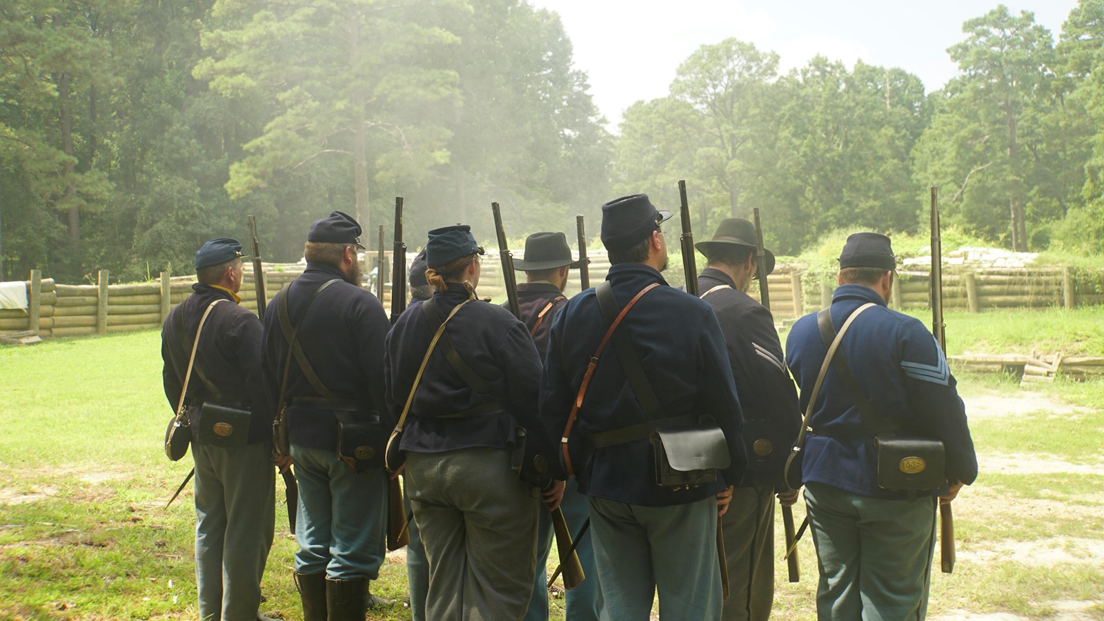 Living historians dresssed in Civil War (U.S.) uniforms stand in formation inside a rebuilt fort.