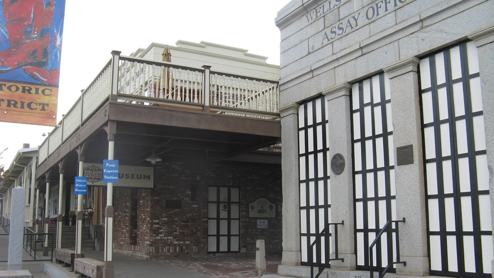 The Wells Fargo Assay Office, a nearly square building faced with granite, stands next to museum.