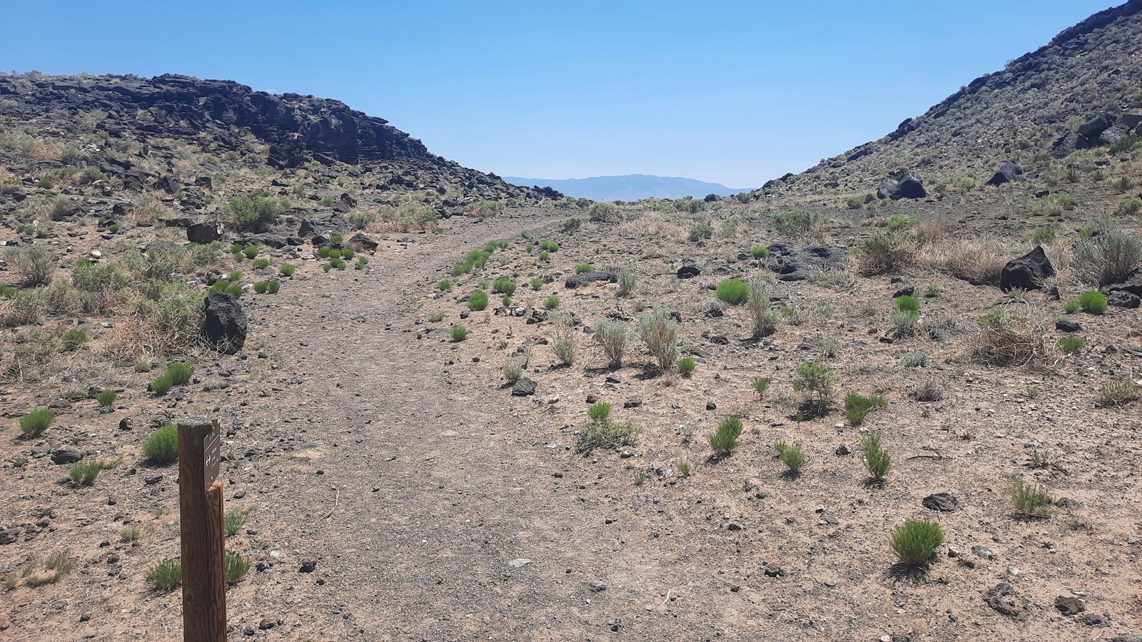 Trail going through an arid volcanic landscape.
