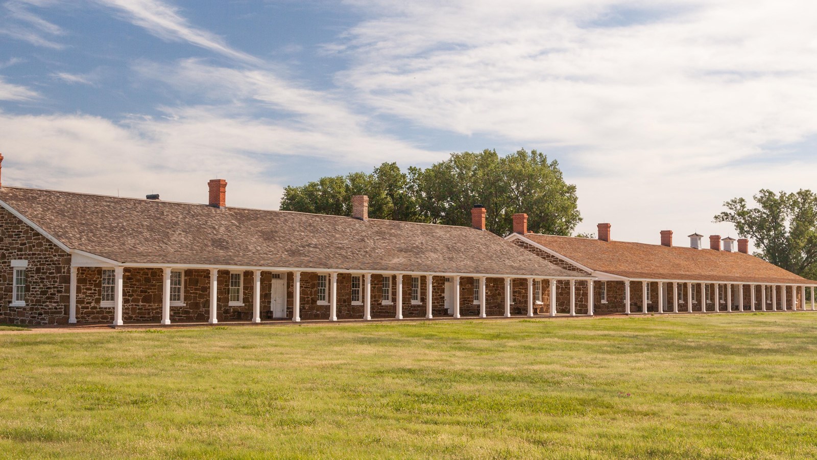 Two ones-story sandstone block buildings, approximately 100 yards long with wooden covered porches.