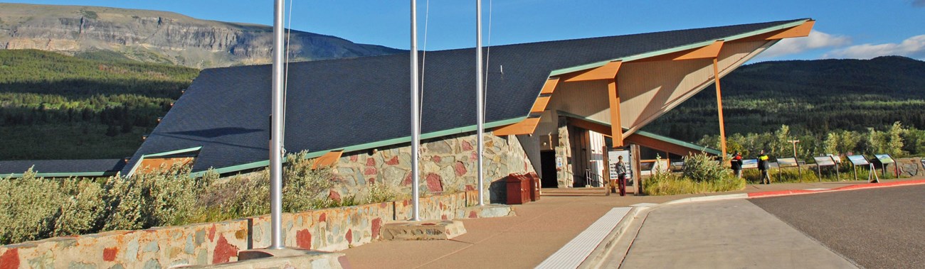 Flagpoles in front of modern building with exaggerated roofline