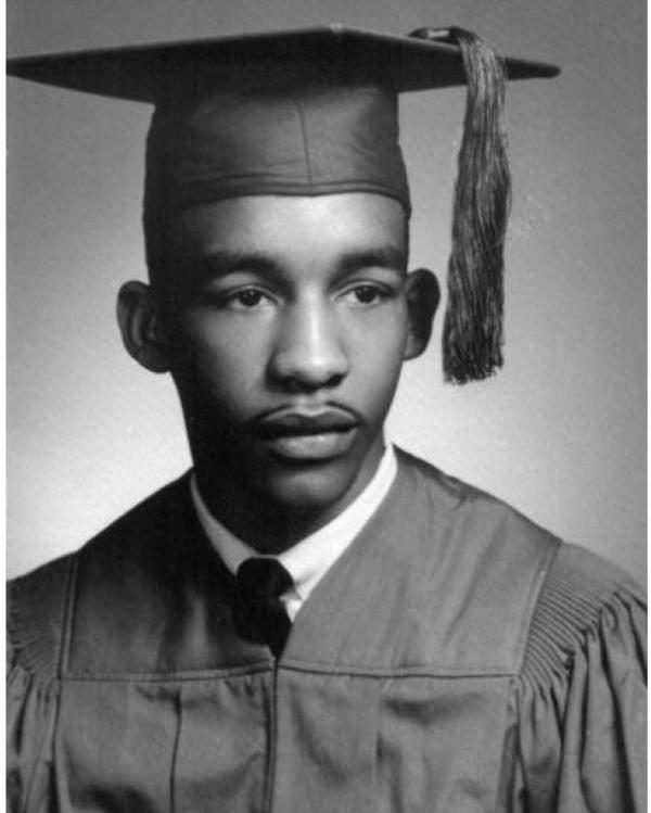 Young boy in high school graduation cap and gown.