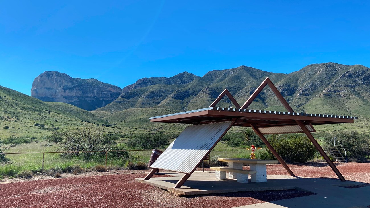 A roadside picnic table stands before a desert mountain vista