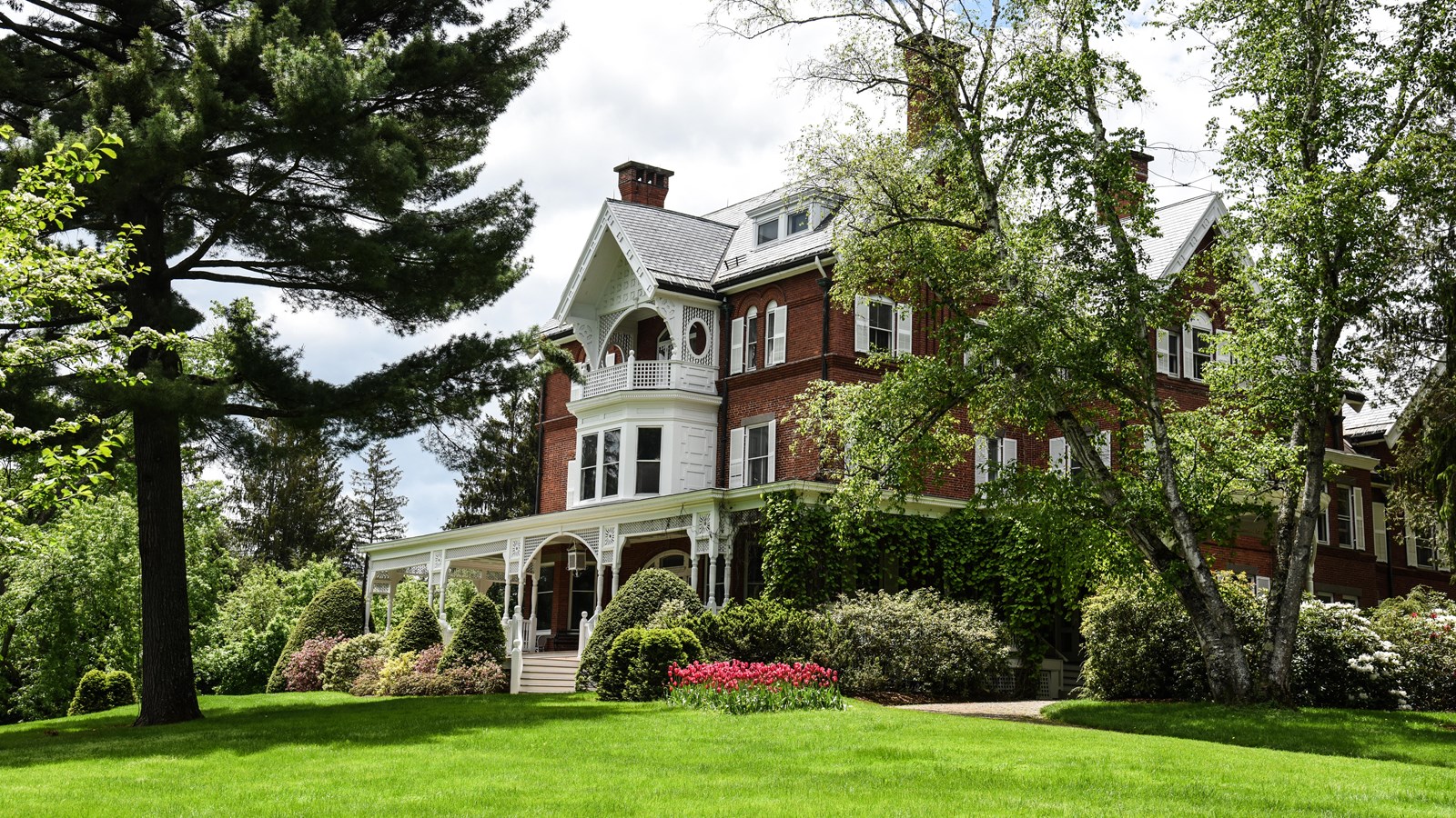 Queen Anne style red brick mansion with white detailing