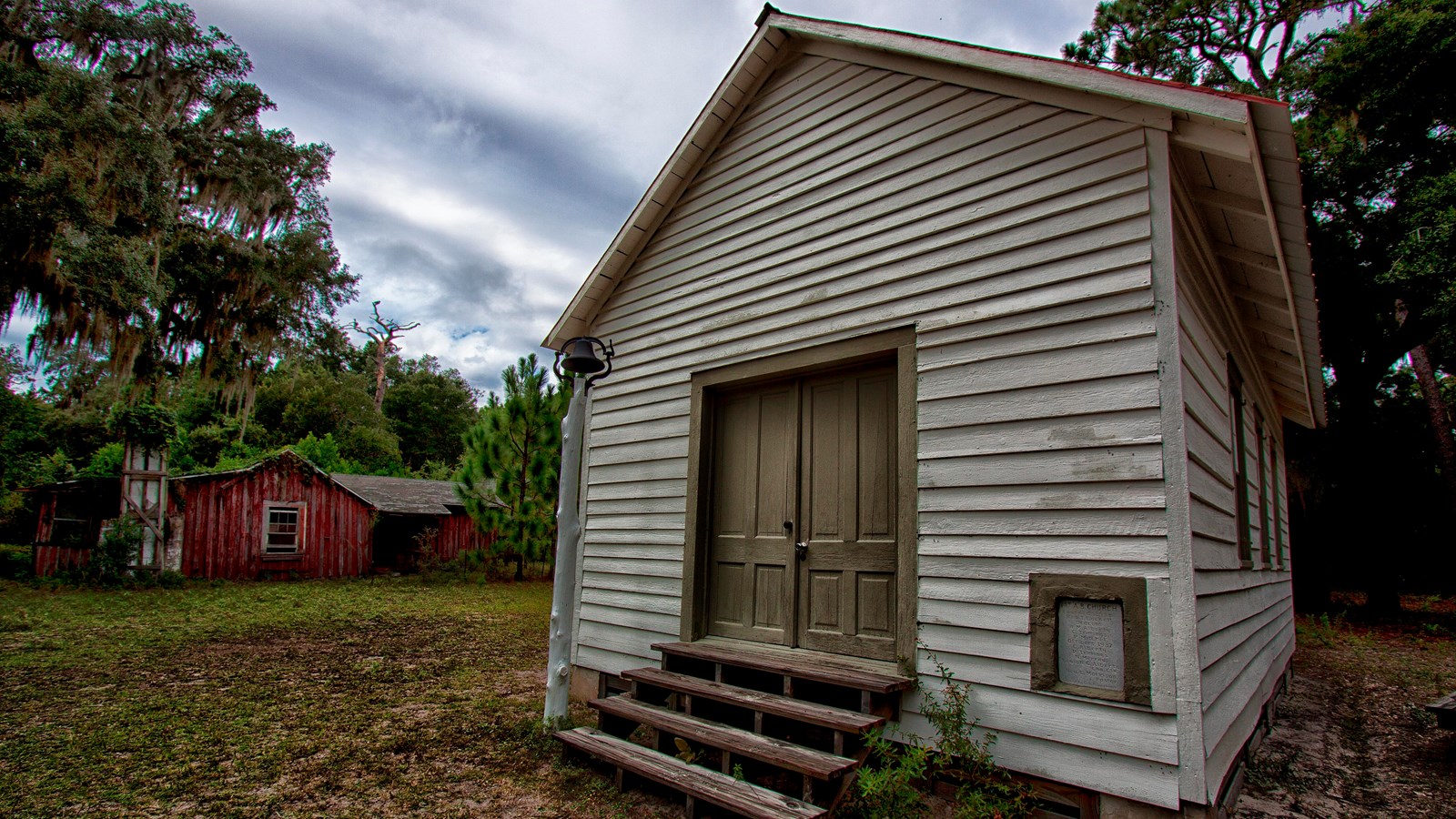 A small single room church with red roof. 