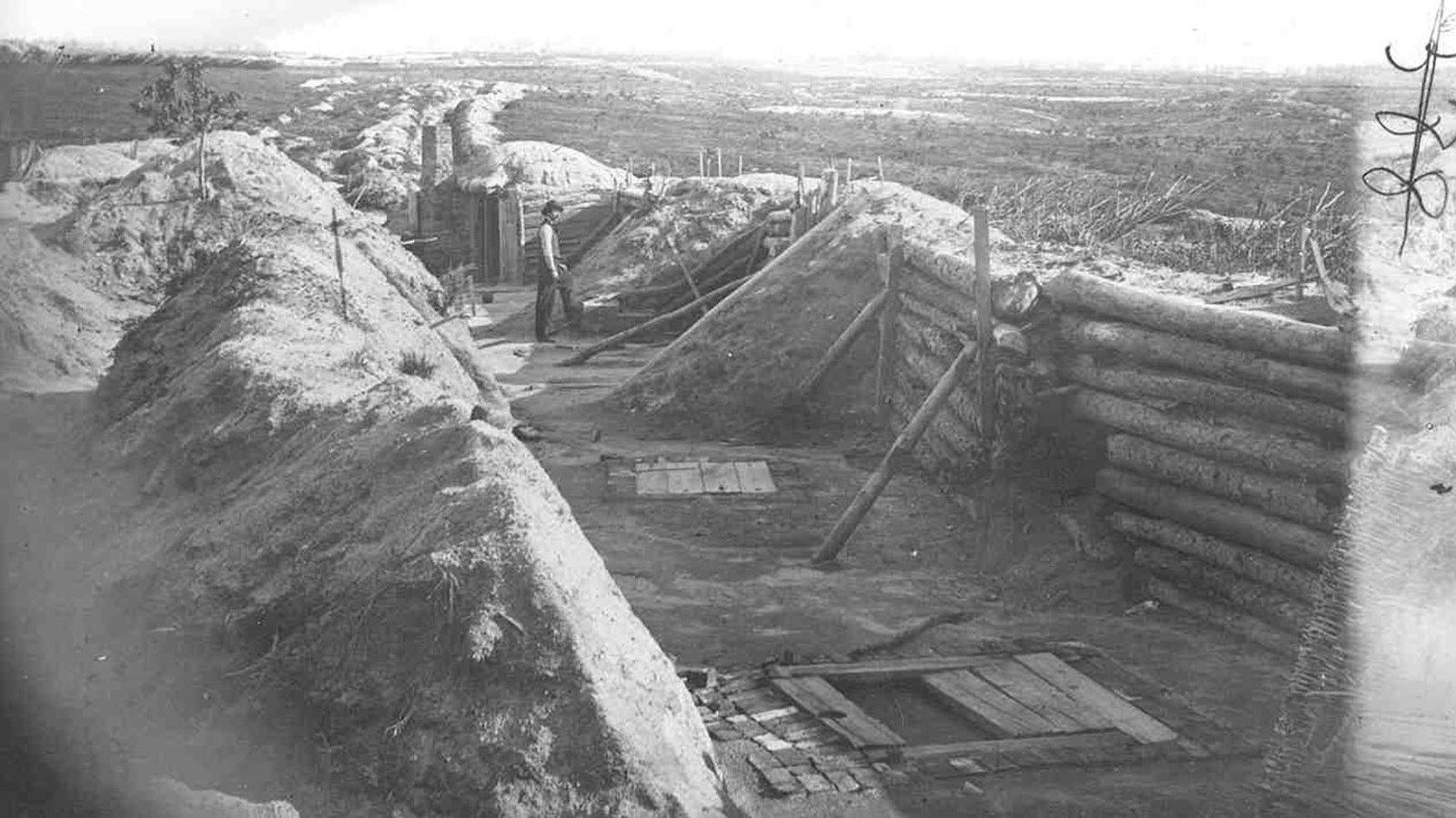 Historic photo of Fort Morton, looking at the trench walls, with a man inside to show depth.