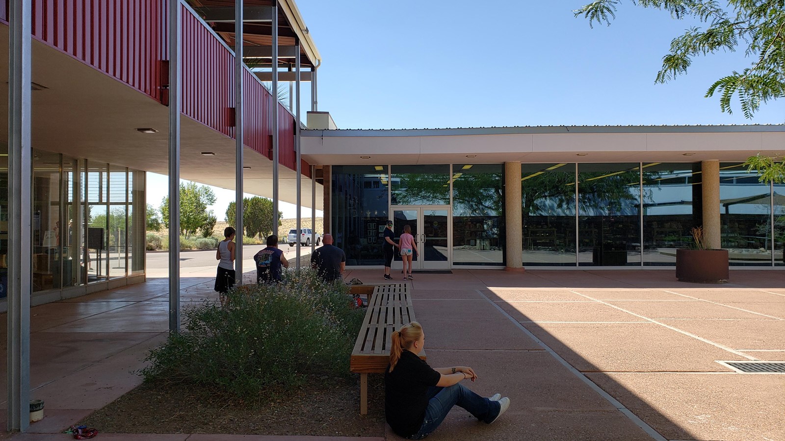 Mid-Century Style building with lots of windows around a plaza under a blue sky.