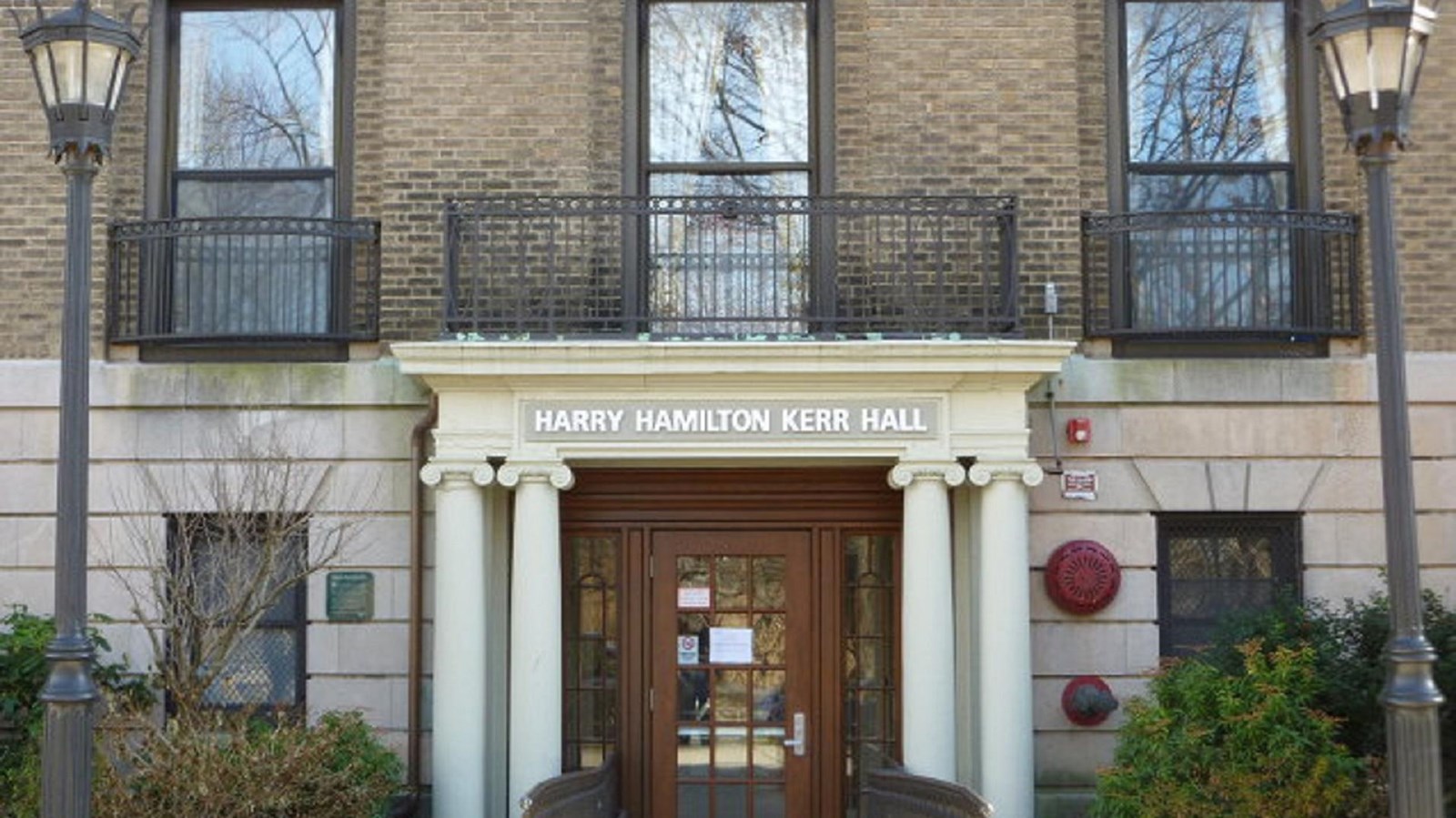 Exterior of brick and stone building with columns surrounding door.