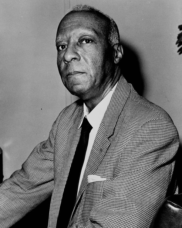 Africacn American man wearing suit jacket and tie and looking into the camera