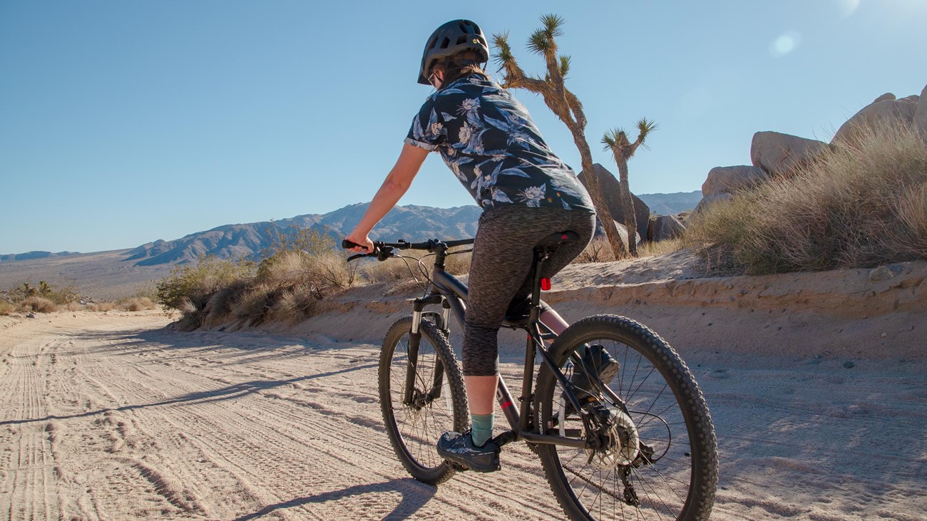 A person rides a bike down an open dirt road