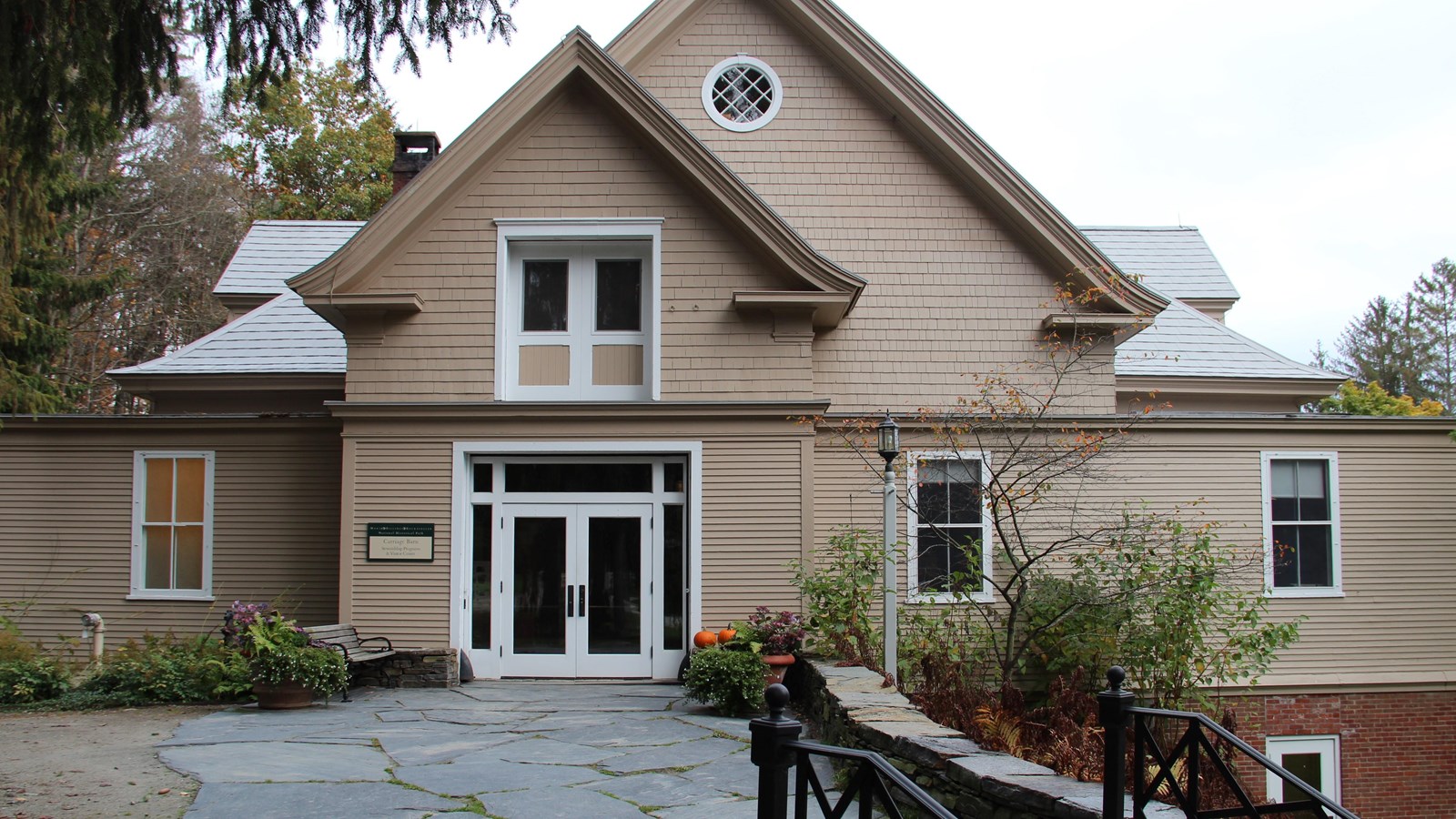 three story building nestled on hill with stone steps leading to entrance