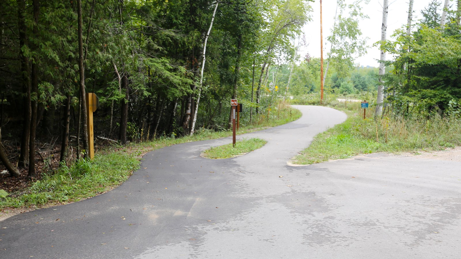 Paved, two-way trail across paved road head towards the river