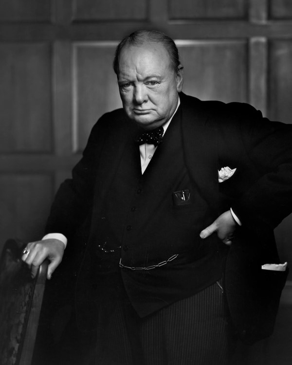 A black and white photograph of a man in a suit with a serious expression on his face 