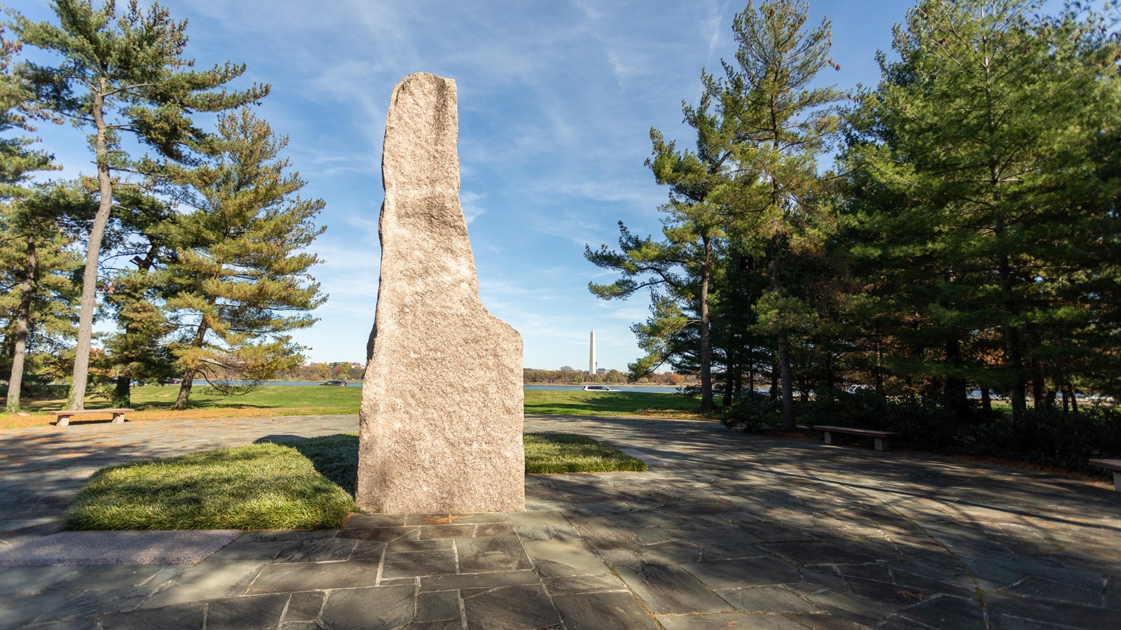 A large, white, stone structure is positioned in the middle of a stone pathway.