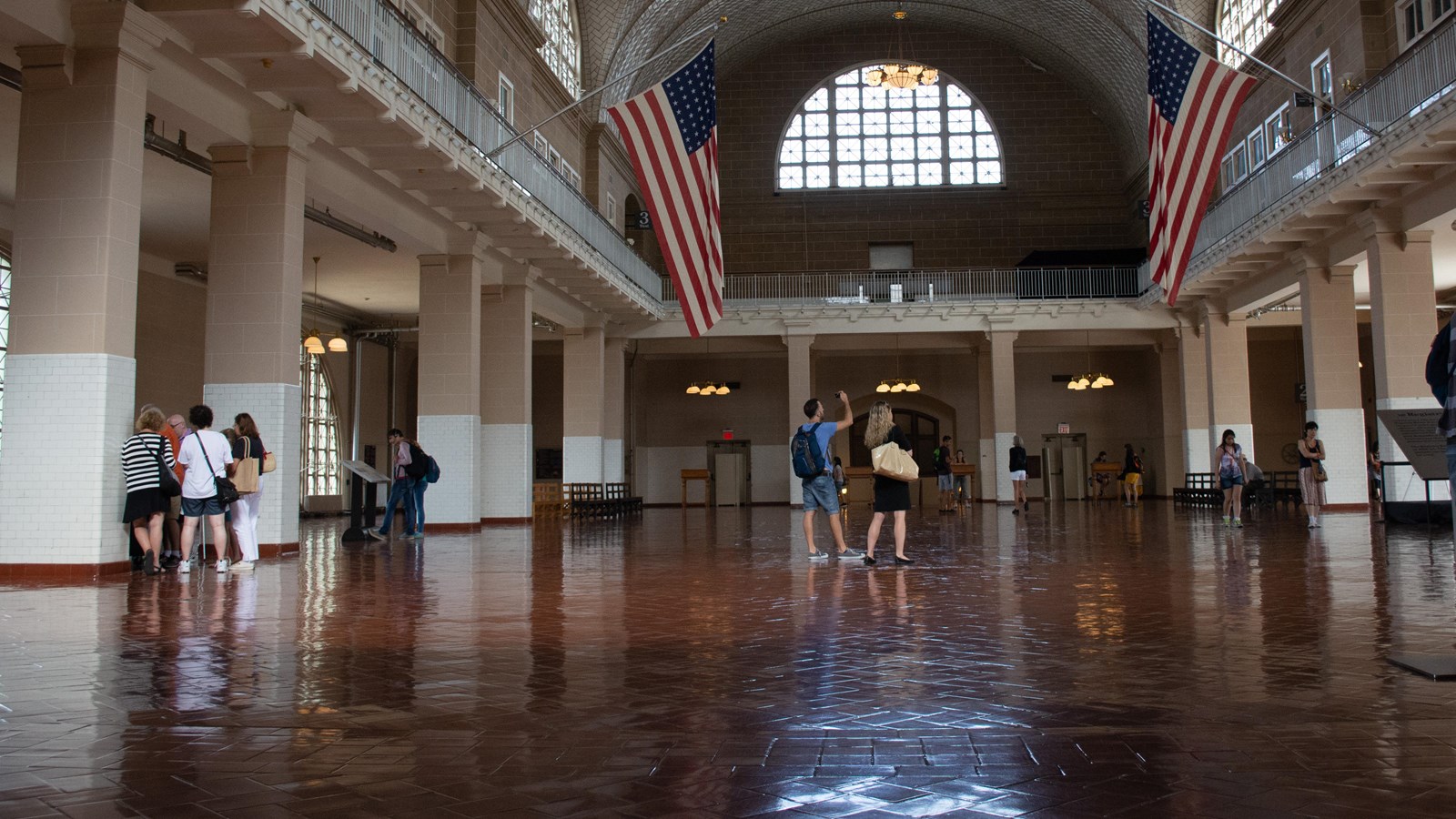 Dark tile floor, barrel vault tile ceiling, surrounding balcony with two American Flags suspended