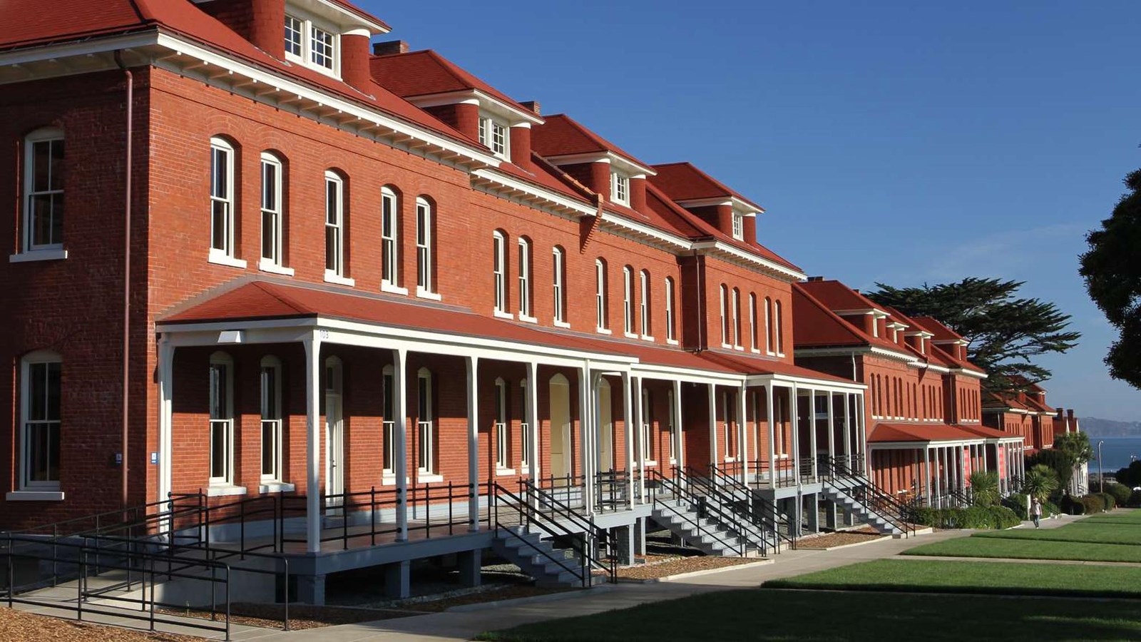 The bright red brick entrances of Montgomery Street Barracks face the Presidio\'s parade ground.