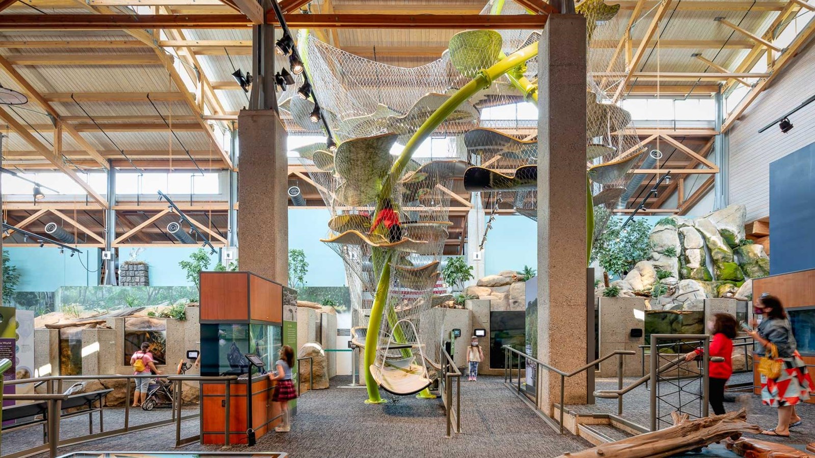Indoor Museum with a multi-level climbing structure surrounded by exhibits and visitors.