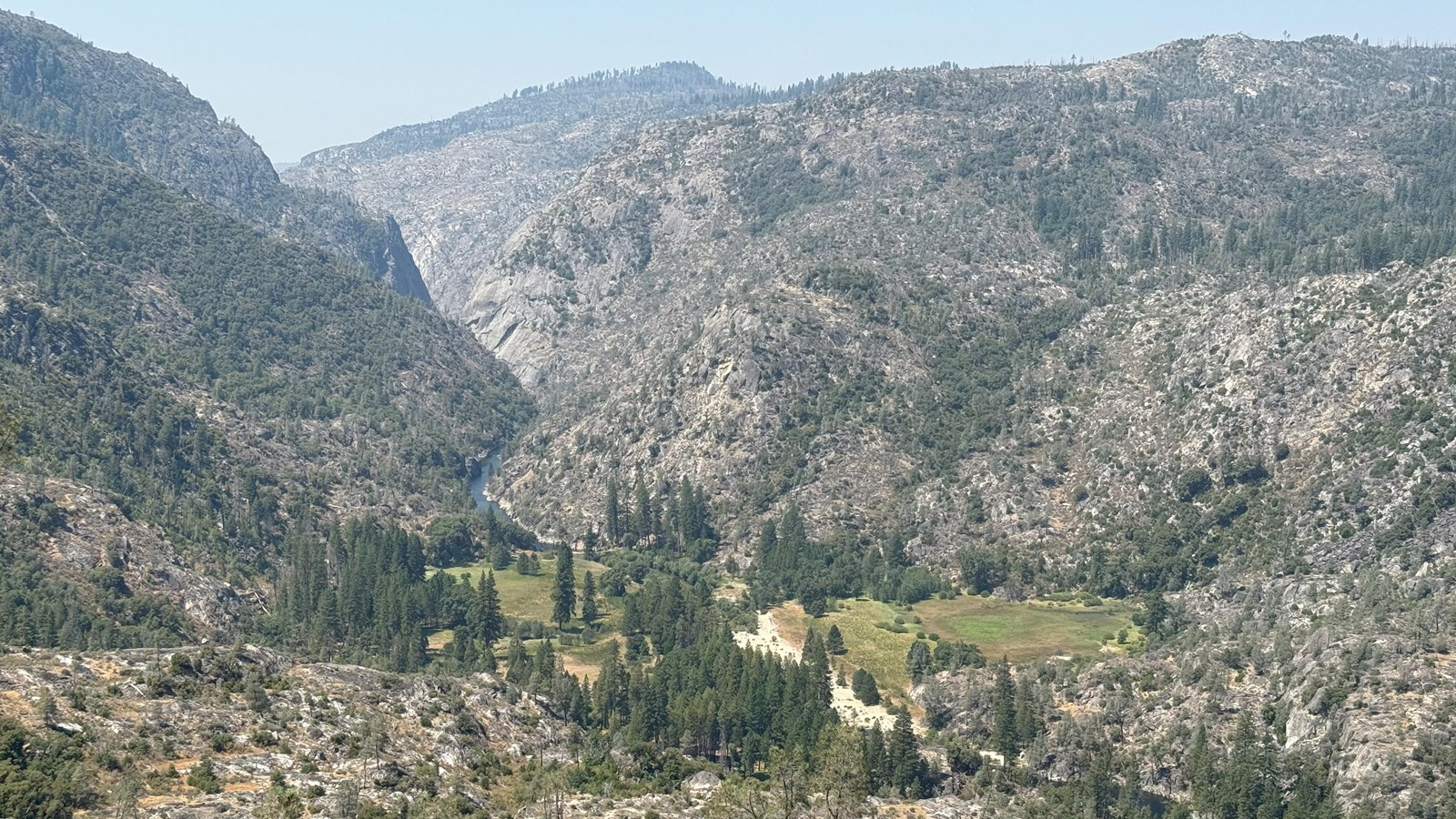 A grassy valley in a granite gorge viewed from high above