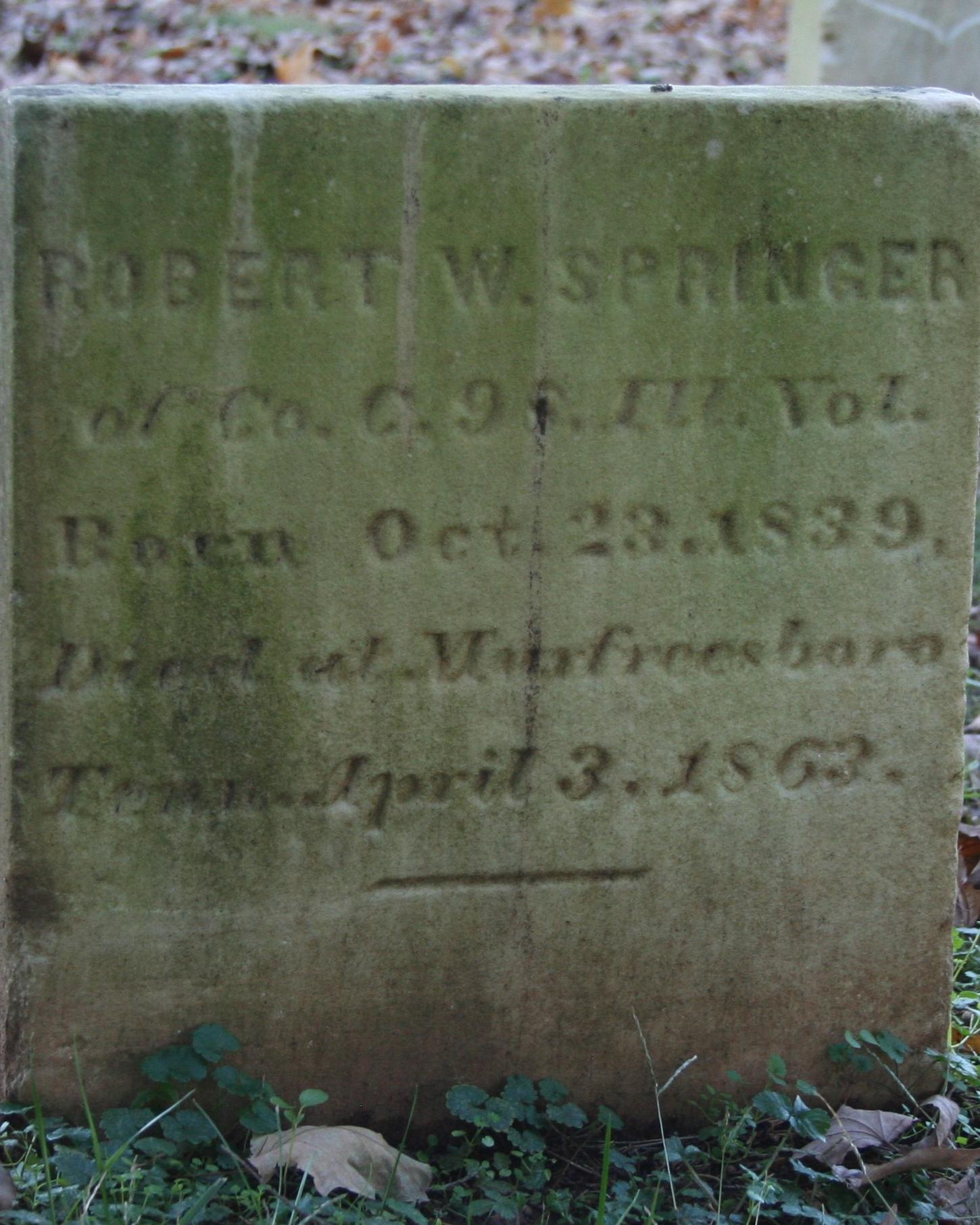 Small, square headstone made out of marble. 
