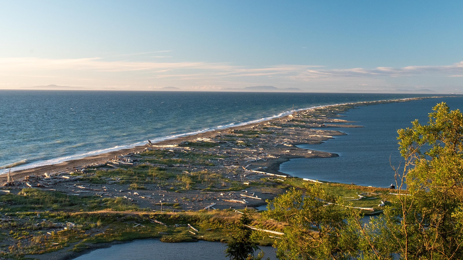 A long rocky spit extends into a large body of water.