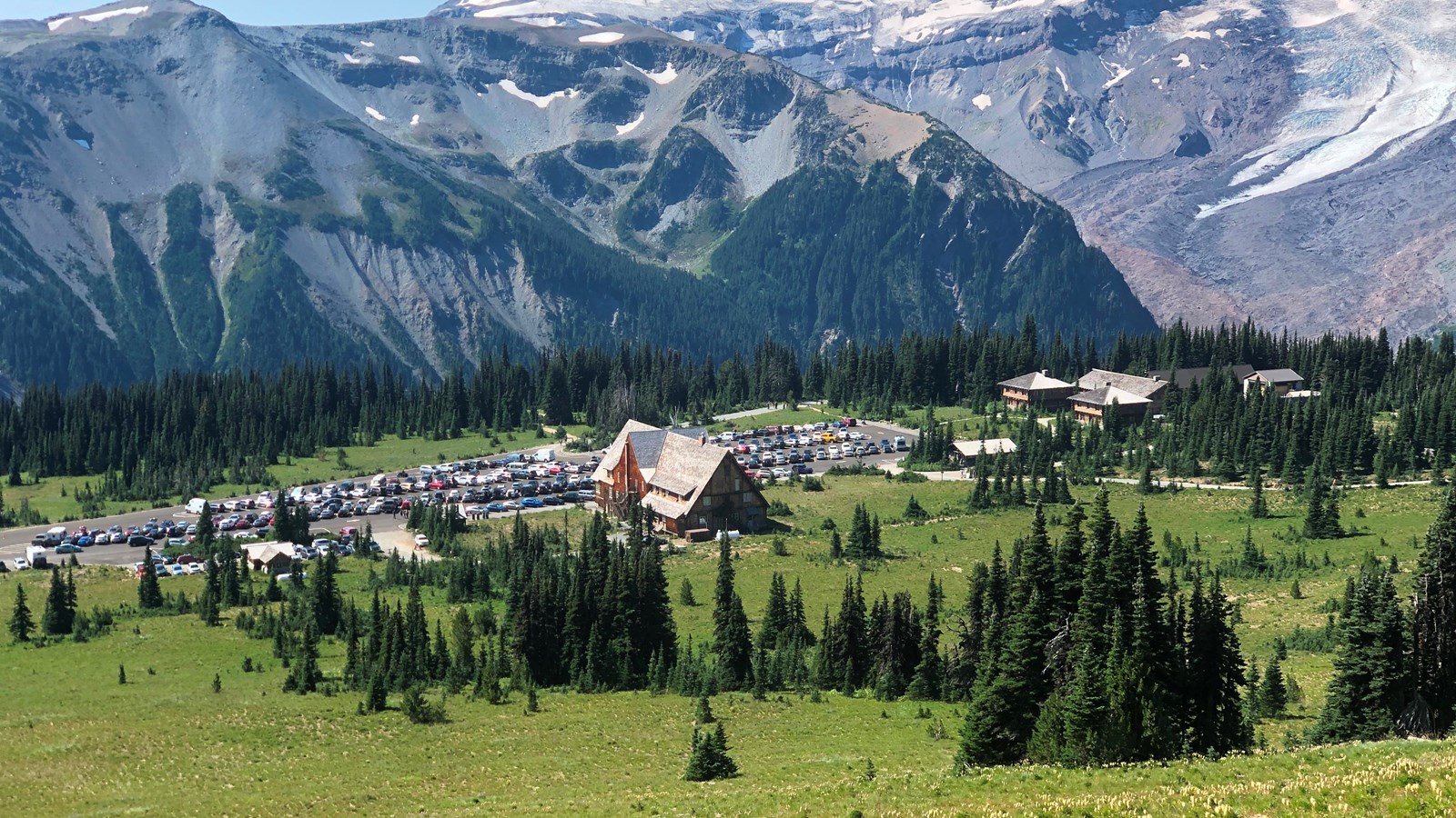 A historic, wooden, rustic building sits in a meadow.