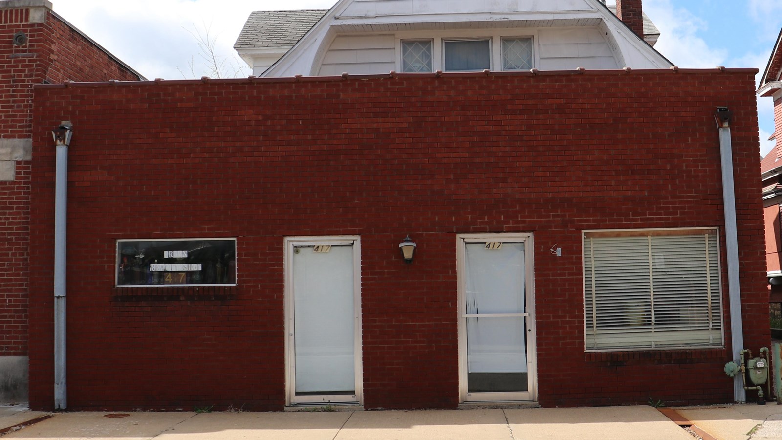 A small one story brick building with two doors and two windows.