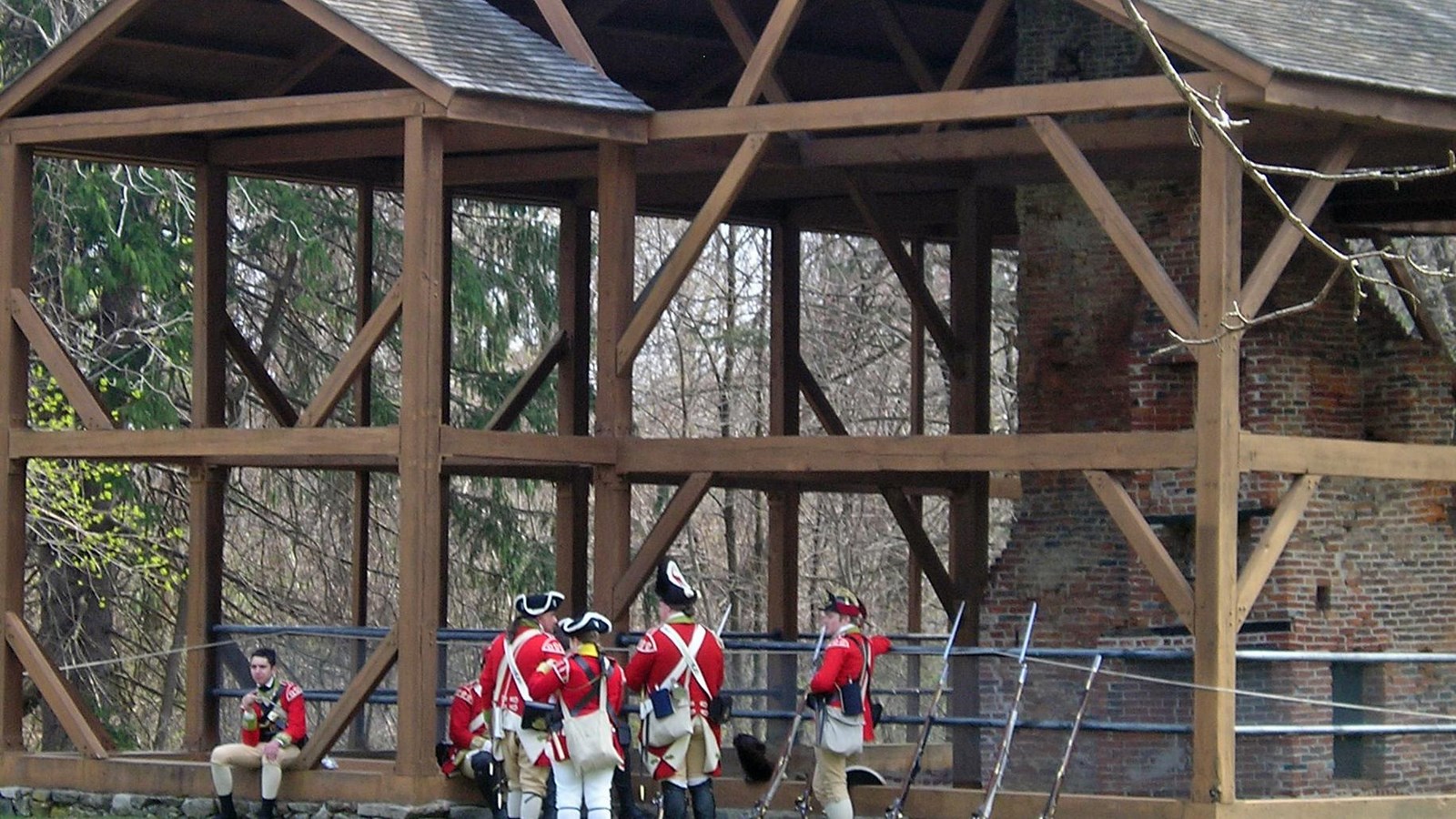 An open timber frame with roof surrounds a 300 year old central chimney with fireplaces.