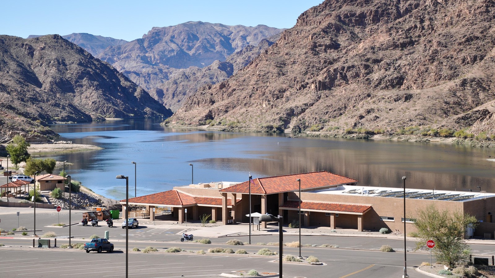 A building looking over a river in a mountainous area.